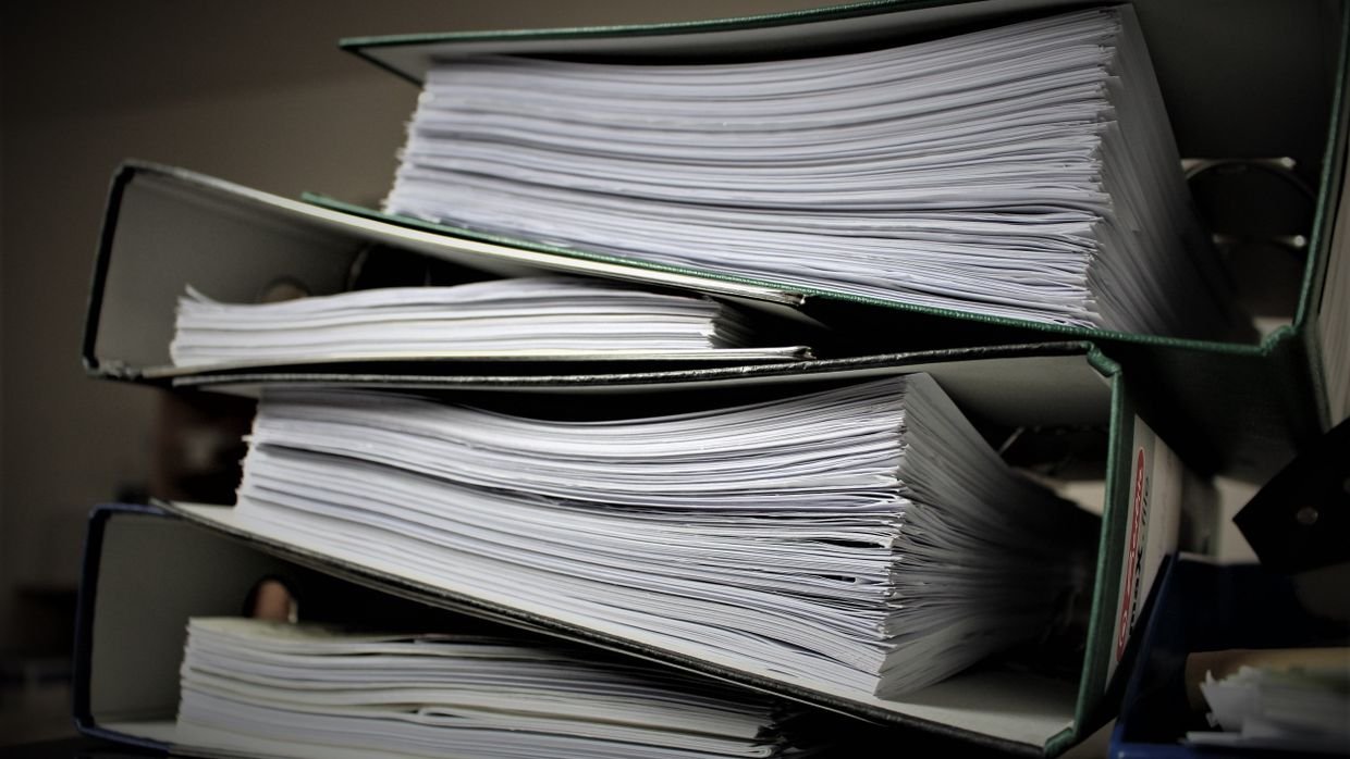 A stack of unsorted paper files.