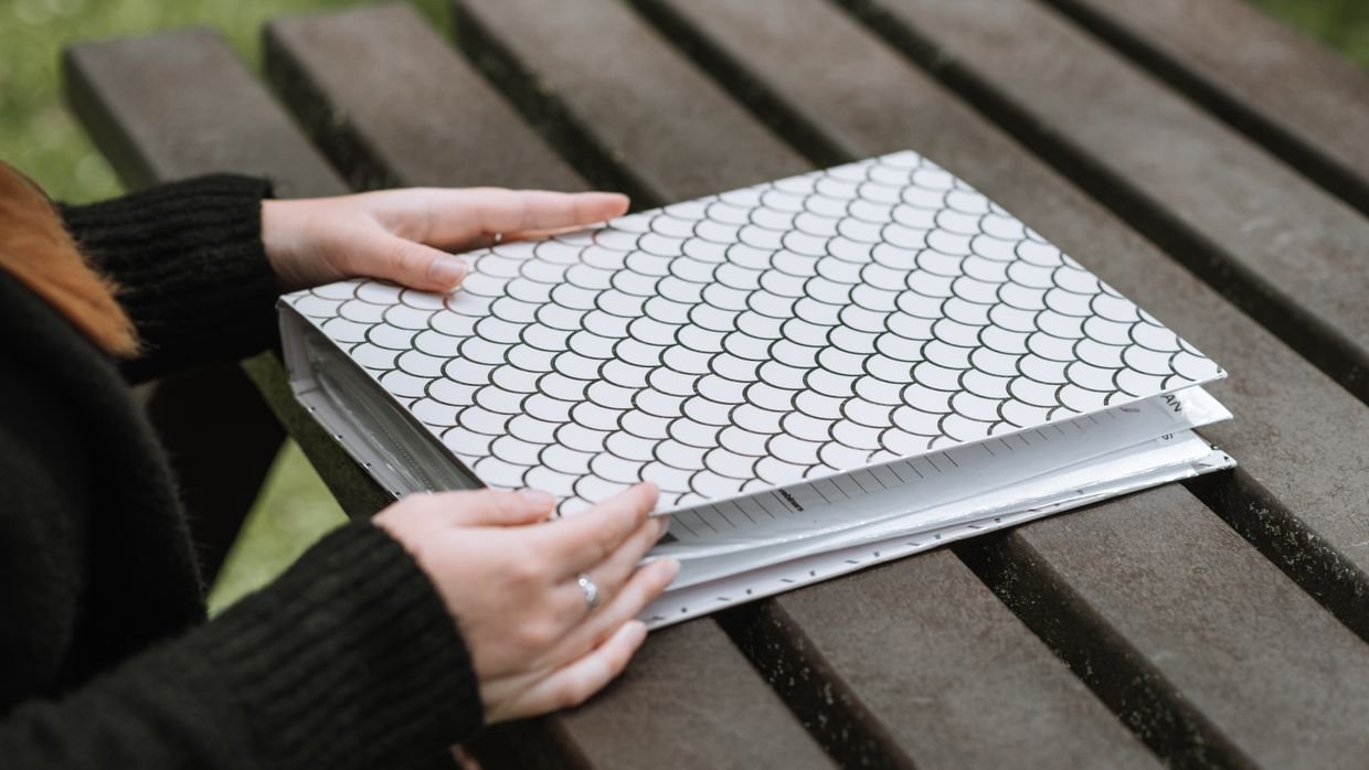 A folder passed from one person to another.