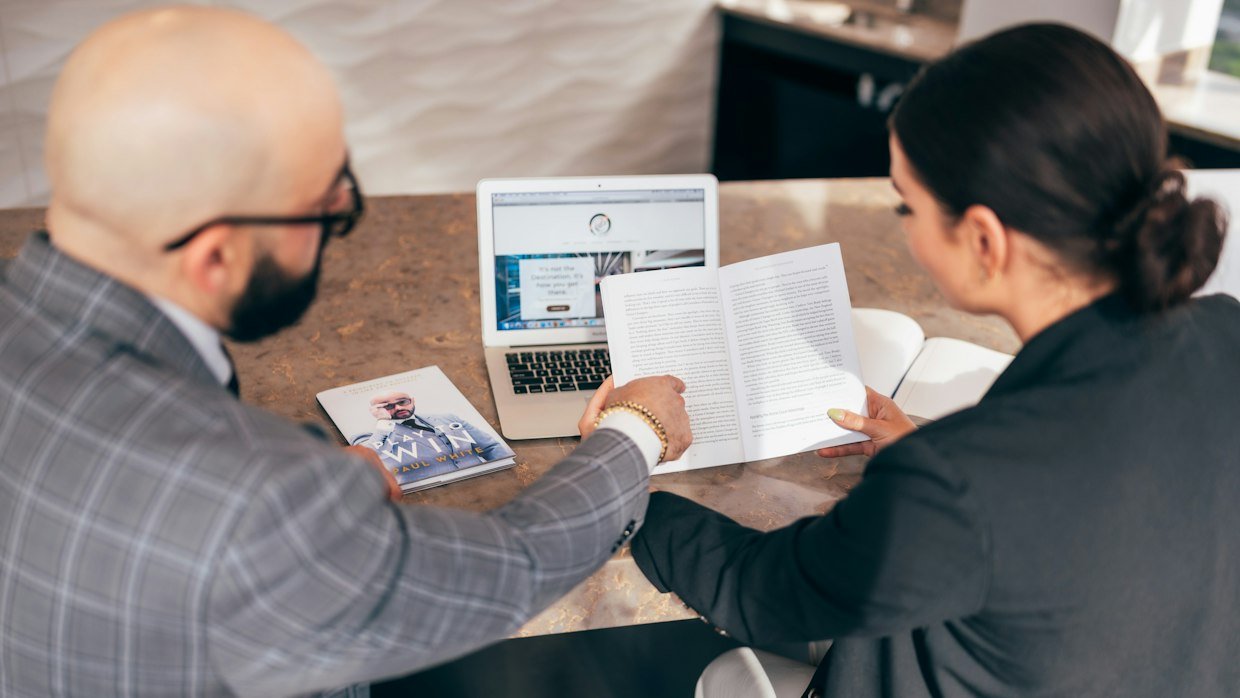 Two people looking over a printed page together.