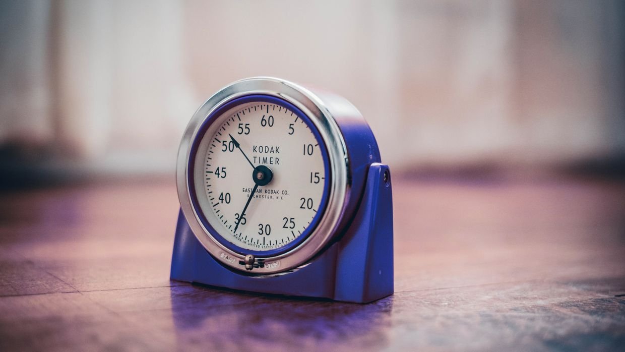 A kitchen timer on a wooden surface.