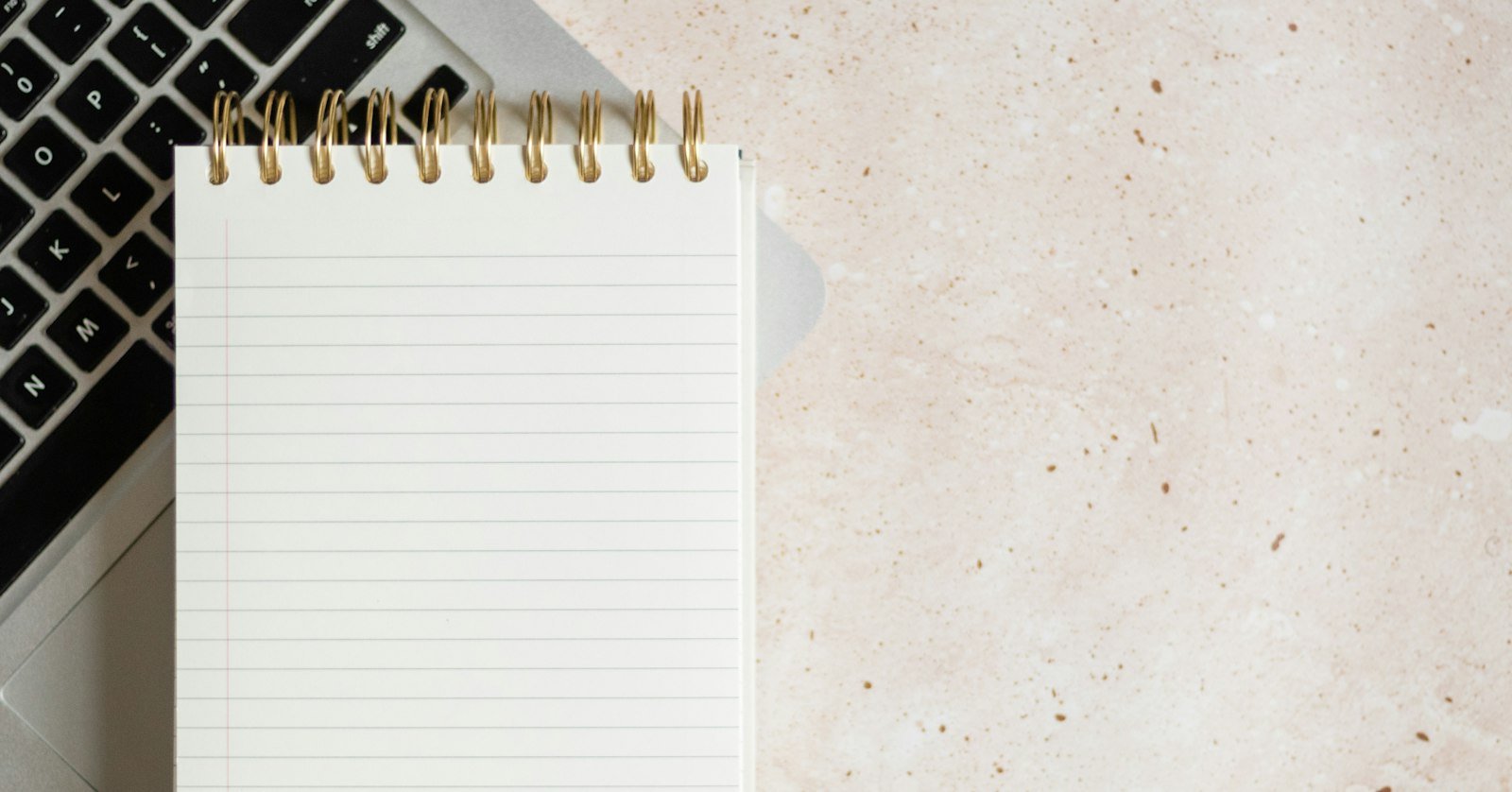 A notebook of handwritten ideas next to a laptop.