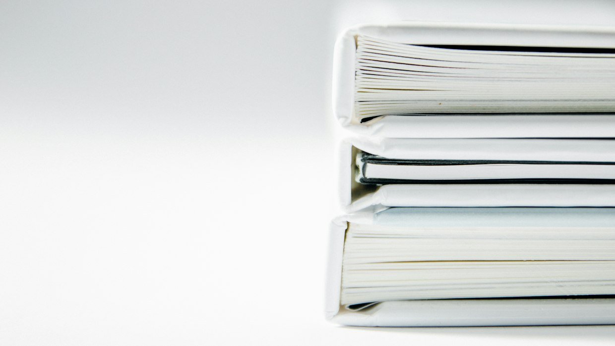 A tall stack of paper documents.