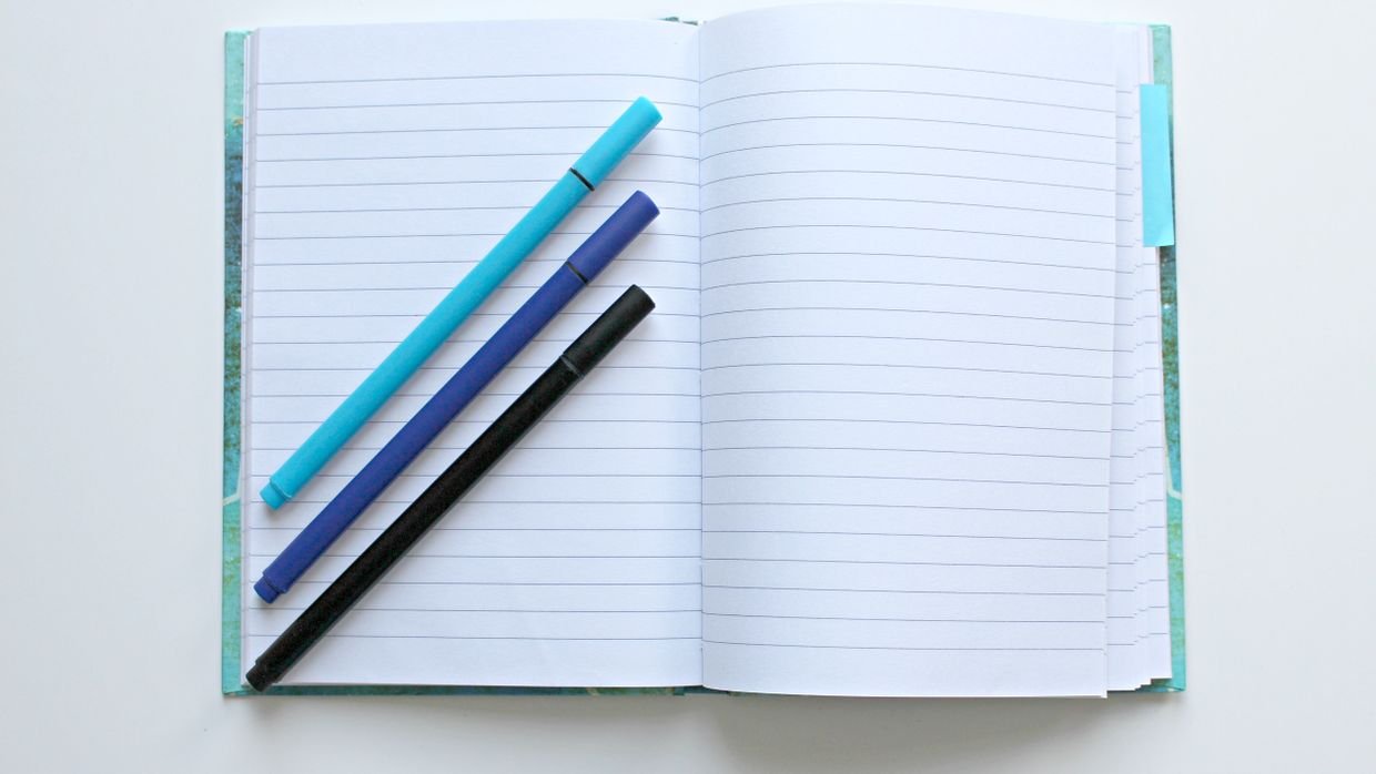 A blank notebook page beside a pen.