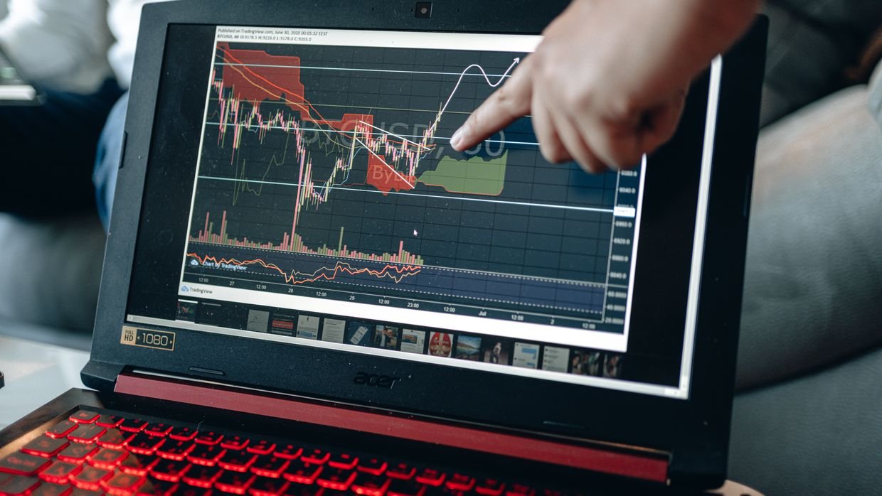 A finger pointing at a line on a laptop screen.