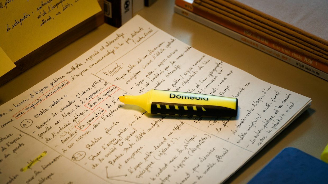 Two sets of notes compared with a highlighter, like checking your own summary against the tool’s.