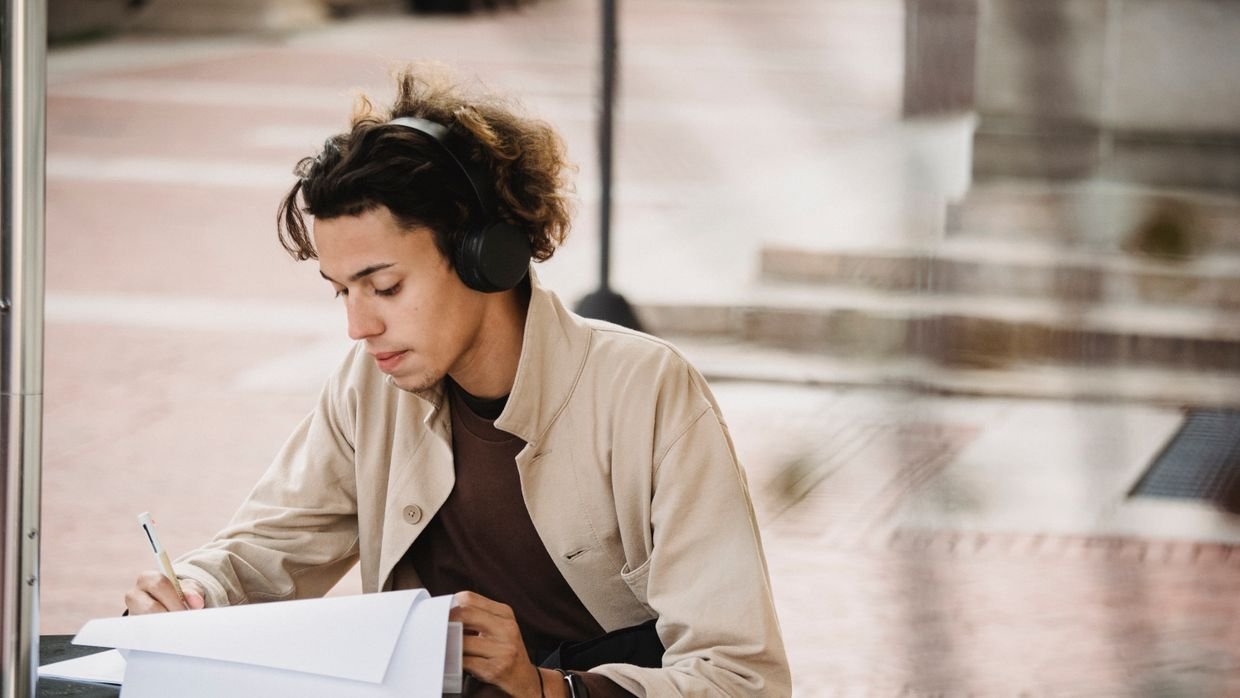 A student concentrating on listening, choosing videos hard enough to test but easy enough to follow.