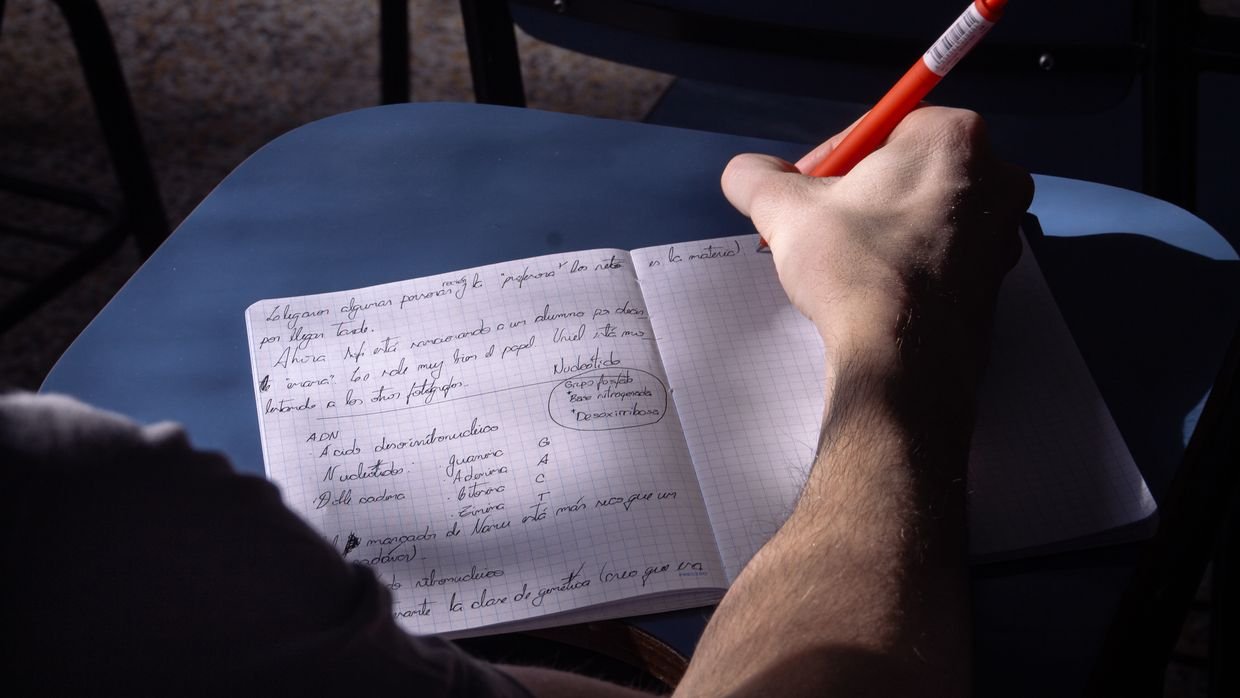 A hand writing a note in a page margin.
