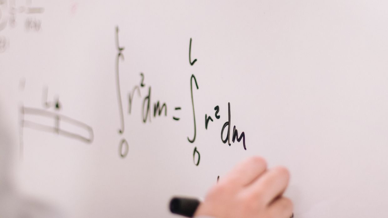 A whiteboard covered in handwritten equations.