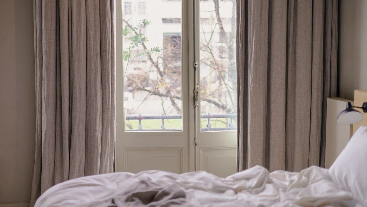 A curtain partly drawn across a window.