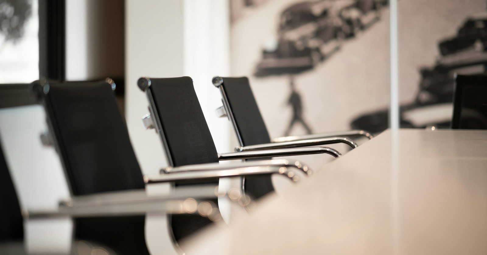 A meeting room table set with notepads.