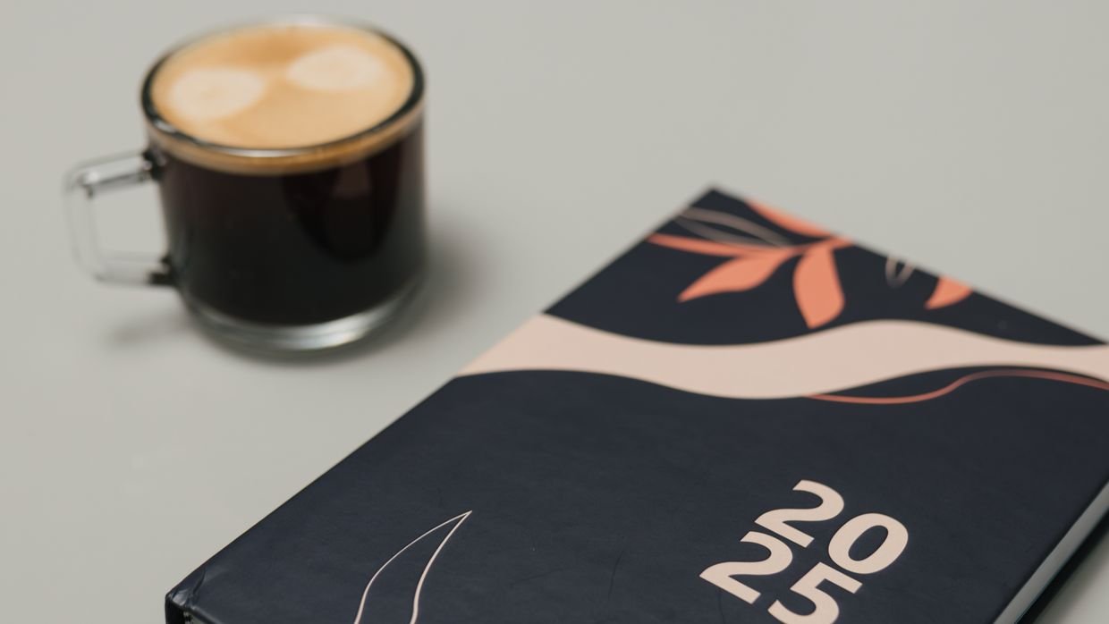 A printed agenda next to a coffee cup.