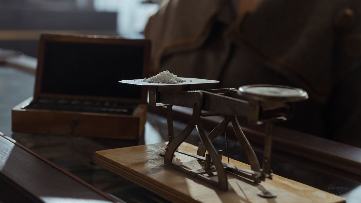 Balance scales holding two small weights.