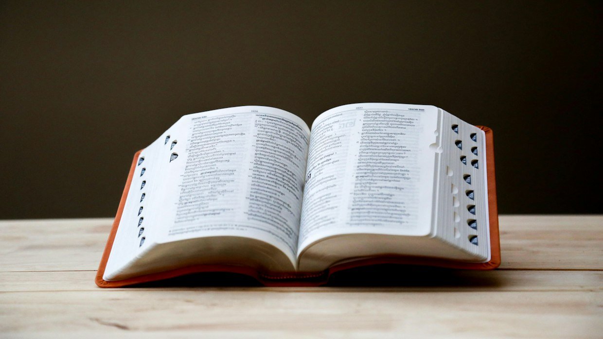 An open dictionary lying on a desk.