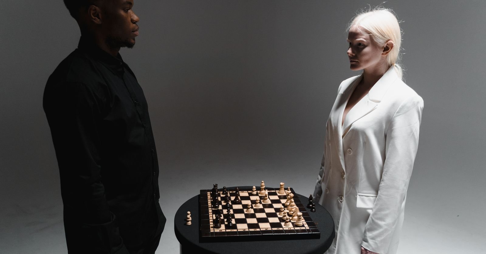 Two chess pieces facing each other on a board.