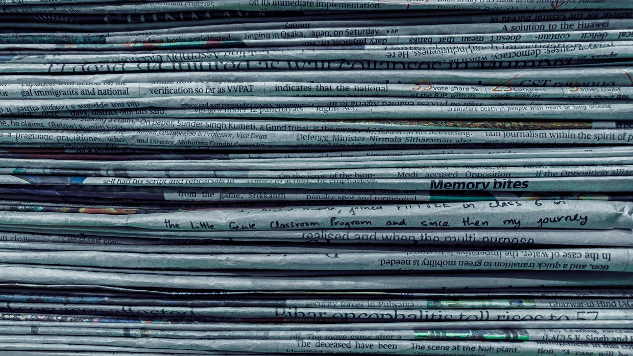 Rows of bound newspaper volumes on shelves.