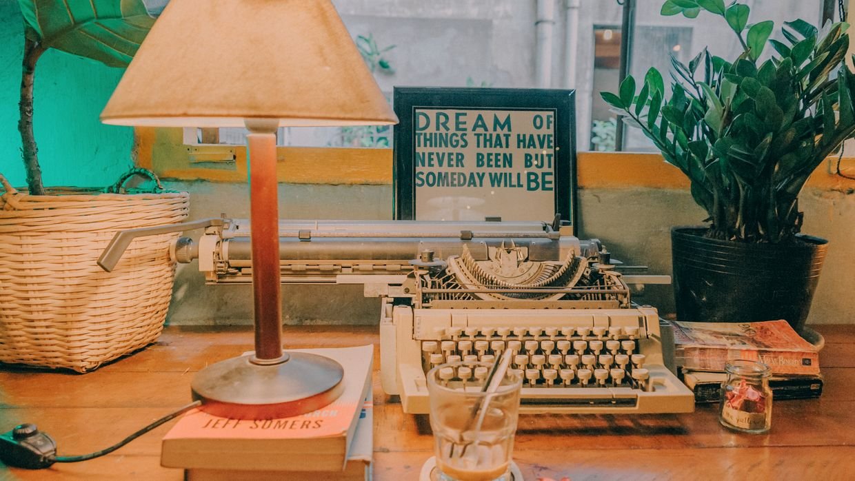 Close-up of someone writing, a reminder that the summary is notes and the newsletter voice is yours.