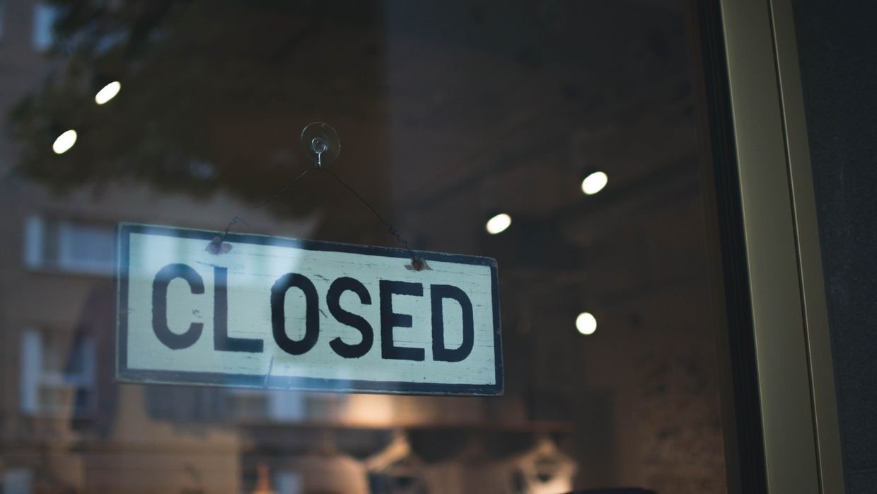 A closed sign hanging in a shop window.