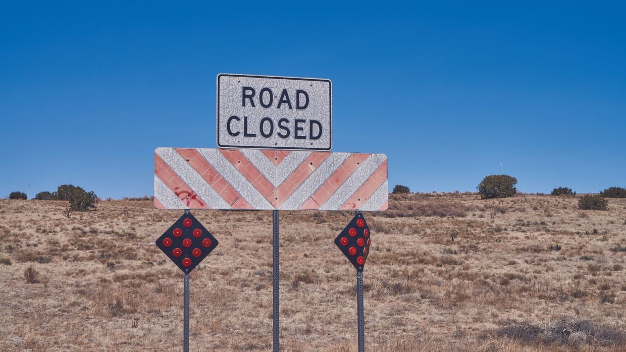 A road closed sign standing in a street.