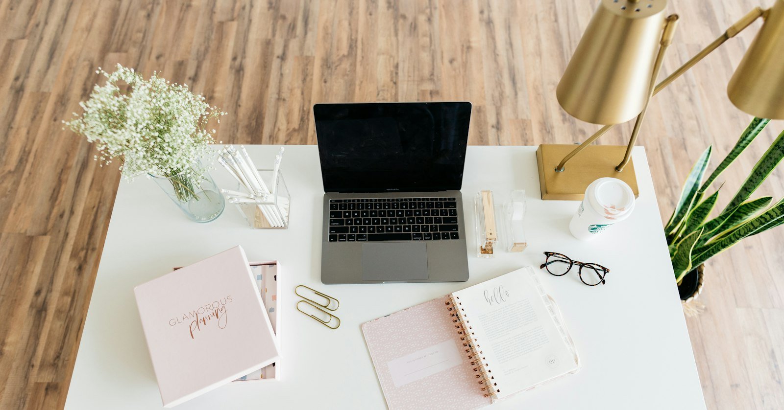 A laptop and notebook on a tidy desk.
