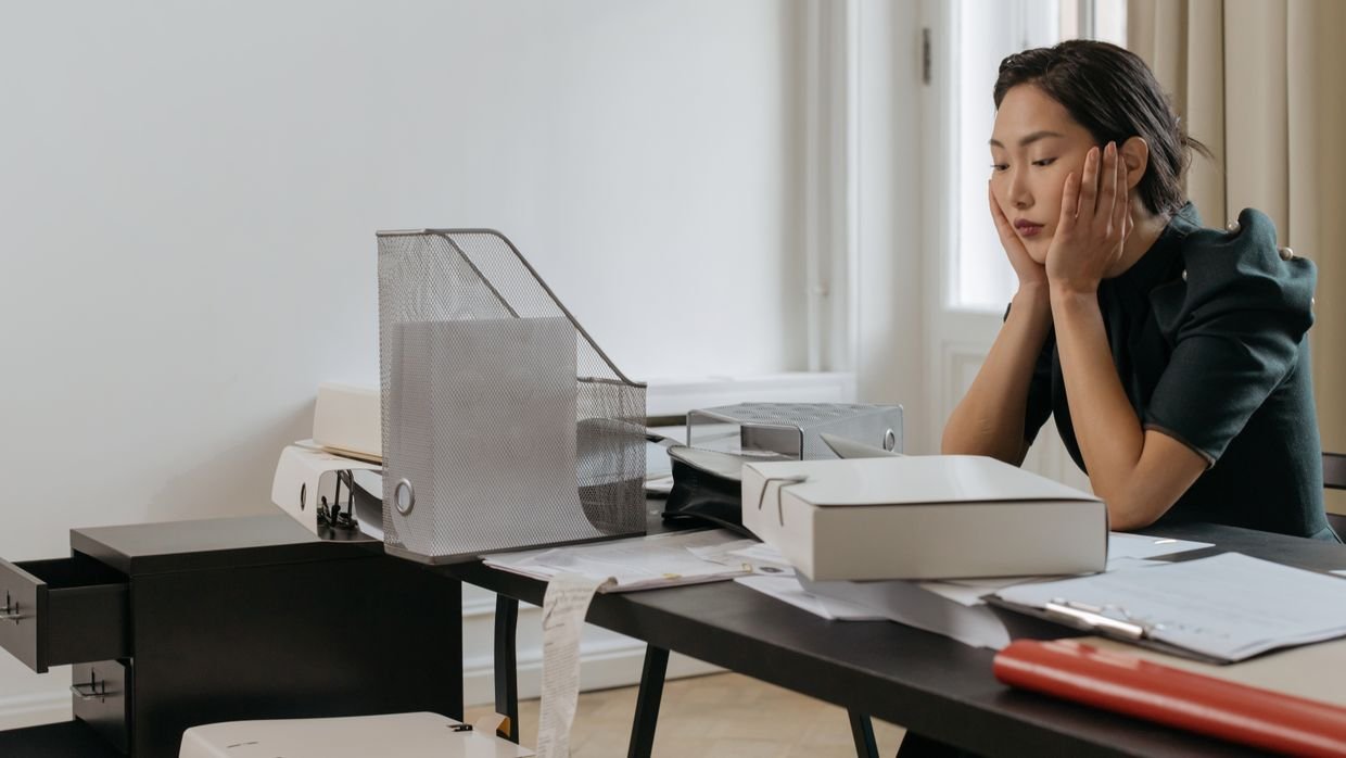 An in-tray overflowing with paperwork.