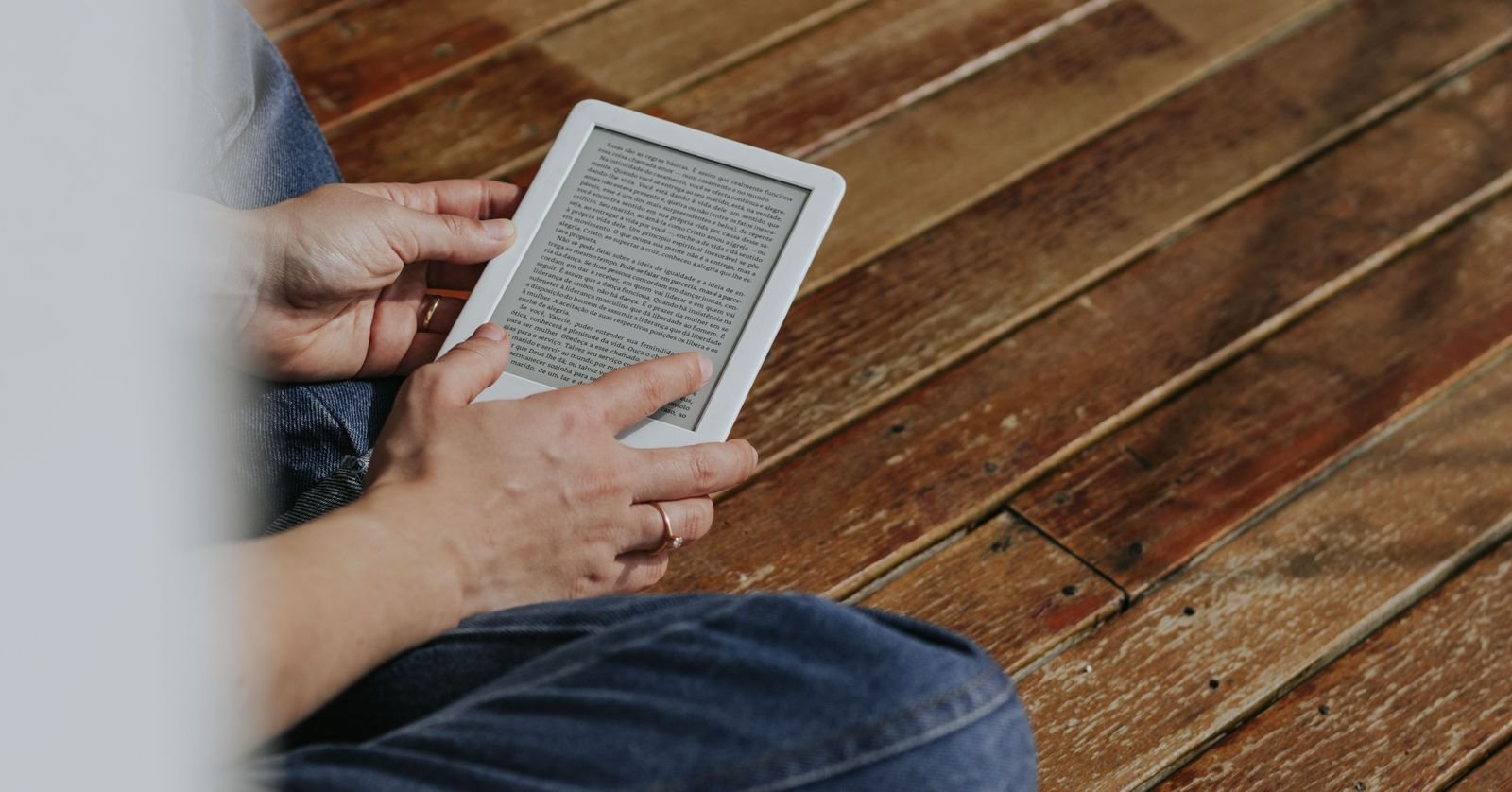 Someone reading a page beside a dark screen.