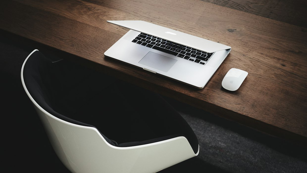 A laptop and notebook side by side on a desk.