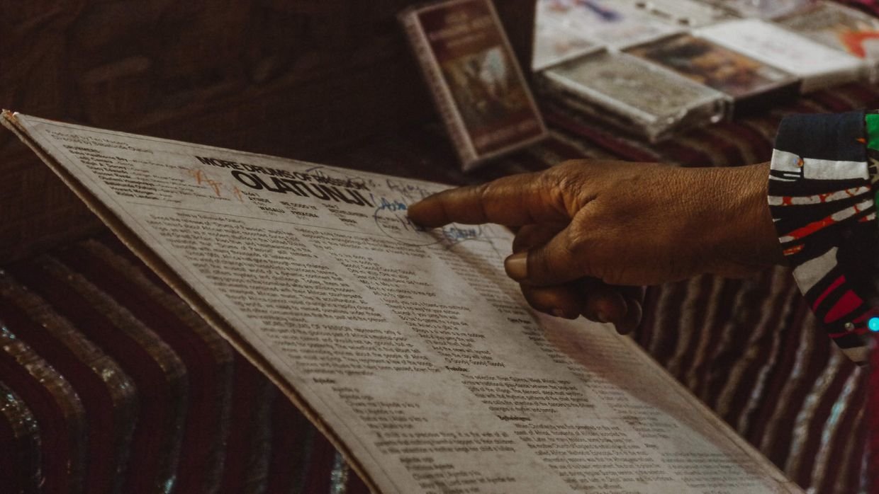 A hand pointing at a line on a printed page.