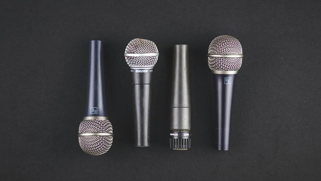 Several microphones on stands lined up.