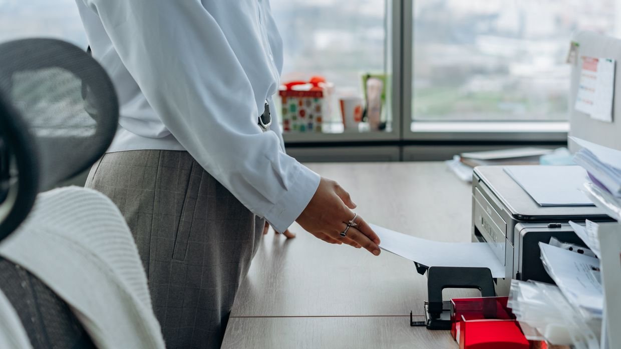 A desktop printer on an office shelf.