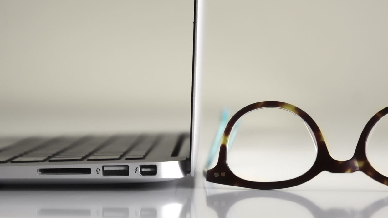 Two laptops side by side on a table, for comparing a link-based summary with a pasted one.
