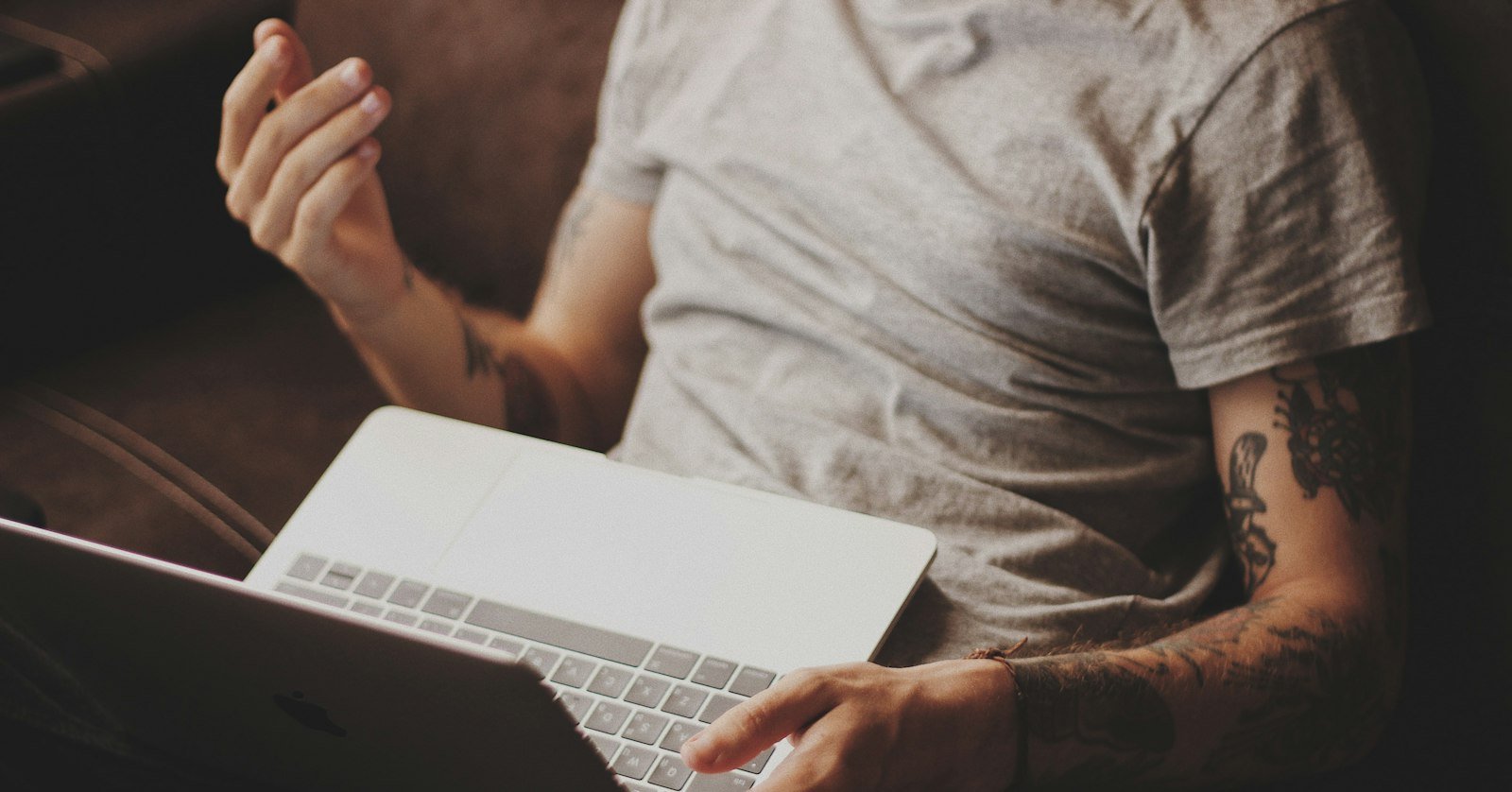A person watching a video on a laptop with a notebook open, weighing a Perplexity summary.