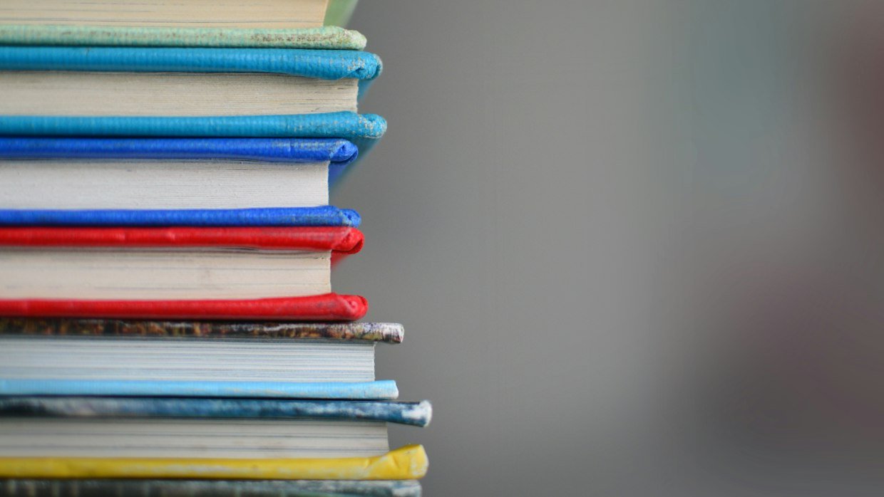 Two separate stacks of books on a table.