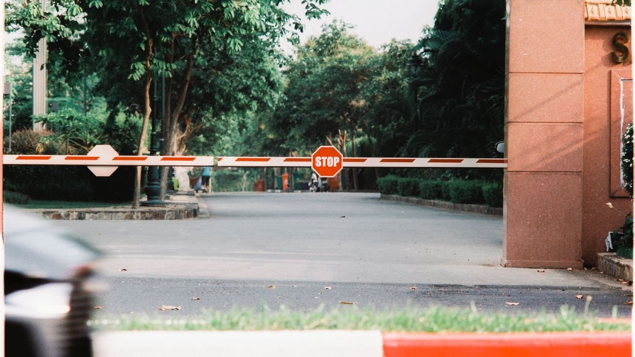 A barrier gate lowered across a road.