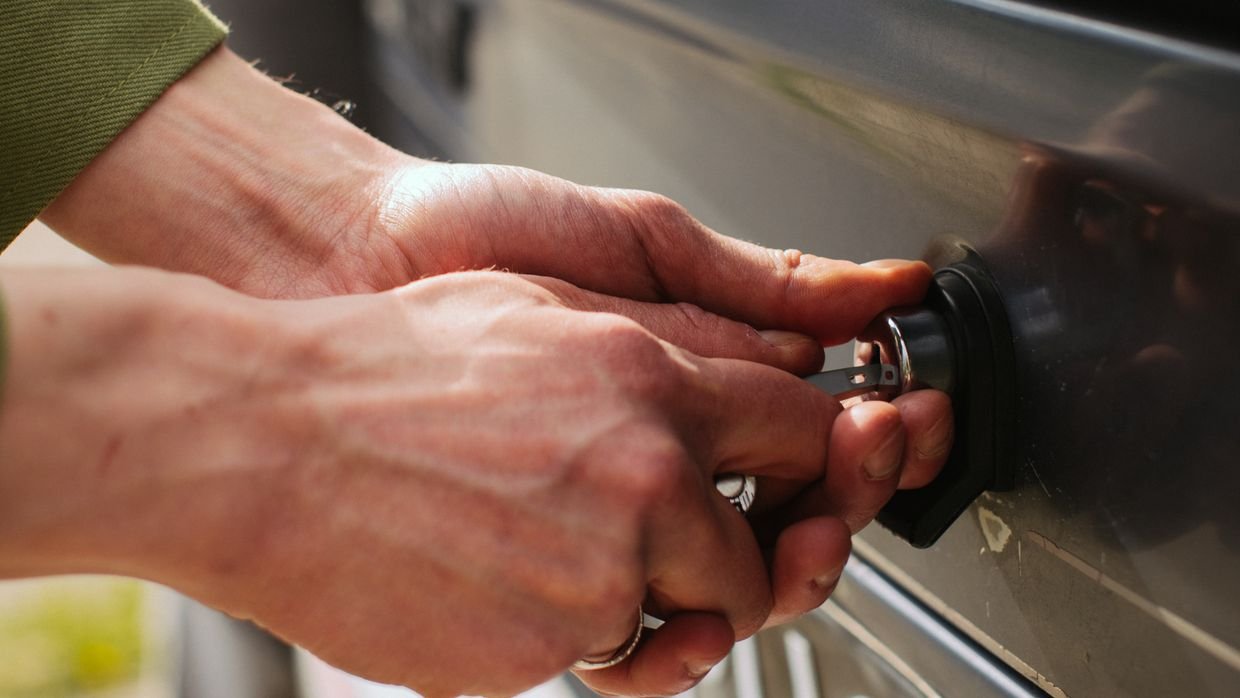 A hand turning a key in a lock.