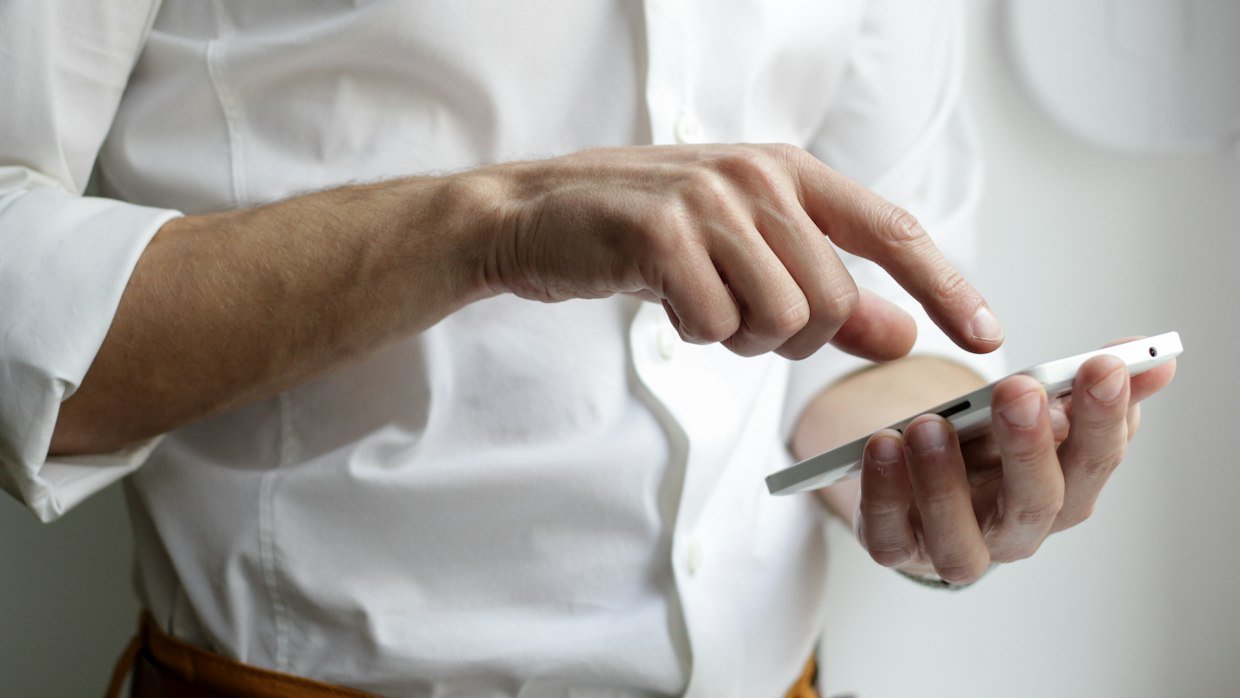 A shopper checking a phone before buying, after reading summaries of several reviews.