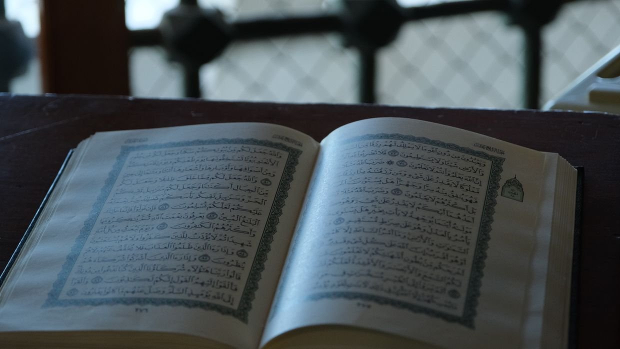 An open book resting on a lectern.