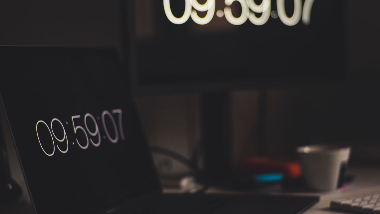 A kitchen timer next to a laptop.