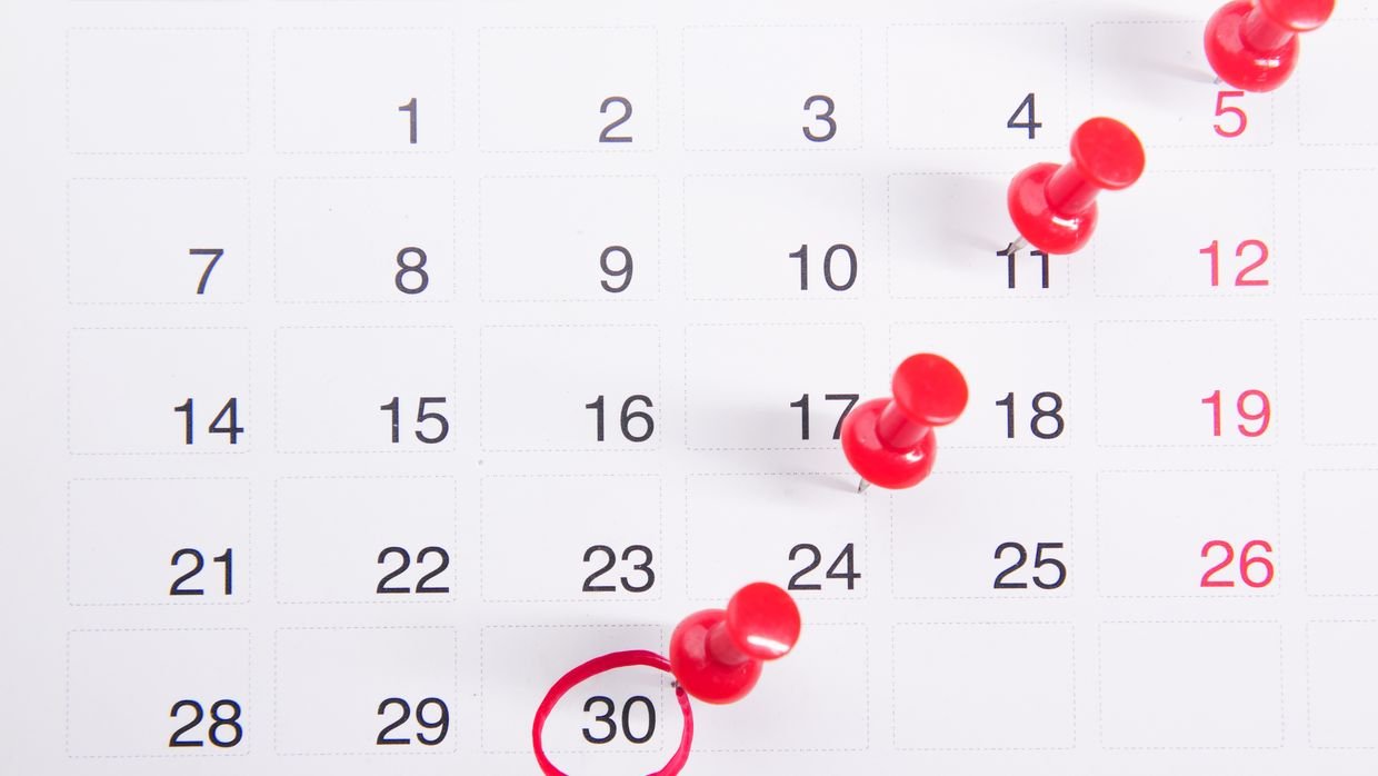 A wall calendar with several dates marked.
