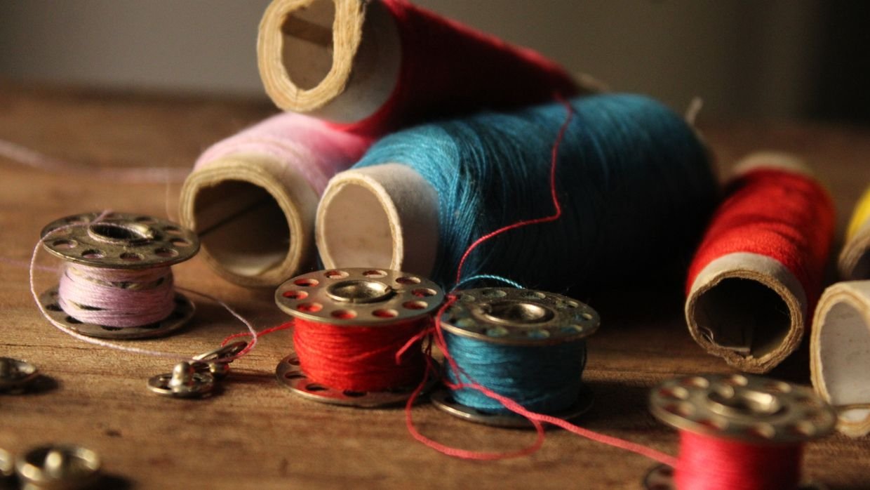 A spool of thread unwinding across a table.