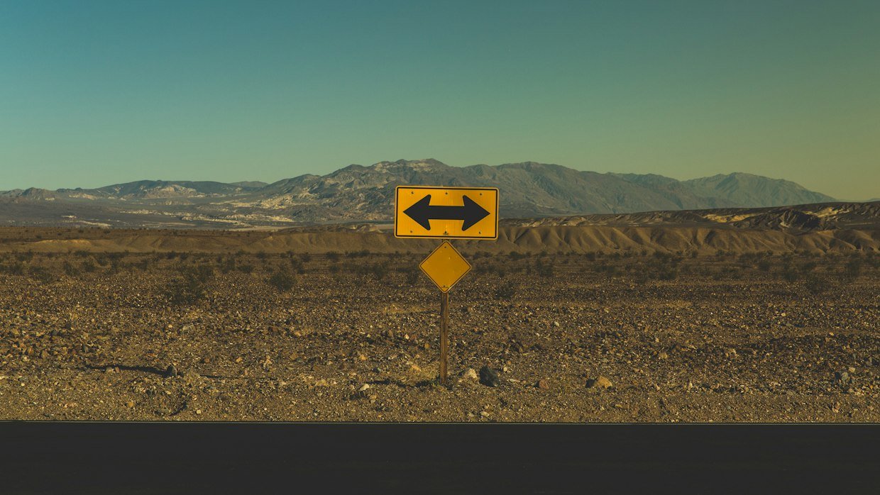 A signpost pointing two ways, for choosing between watching and reading.