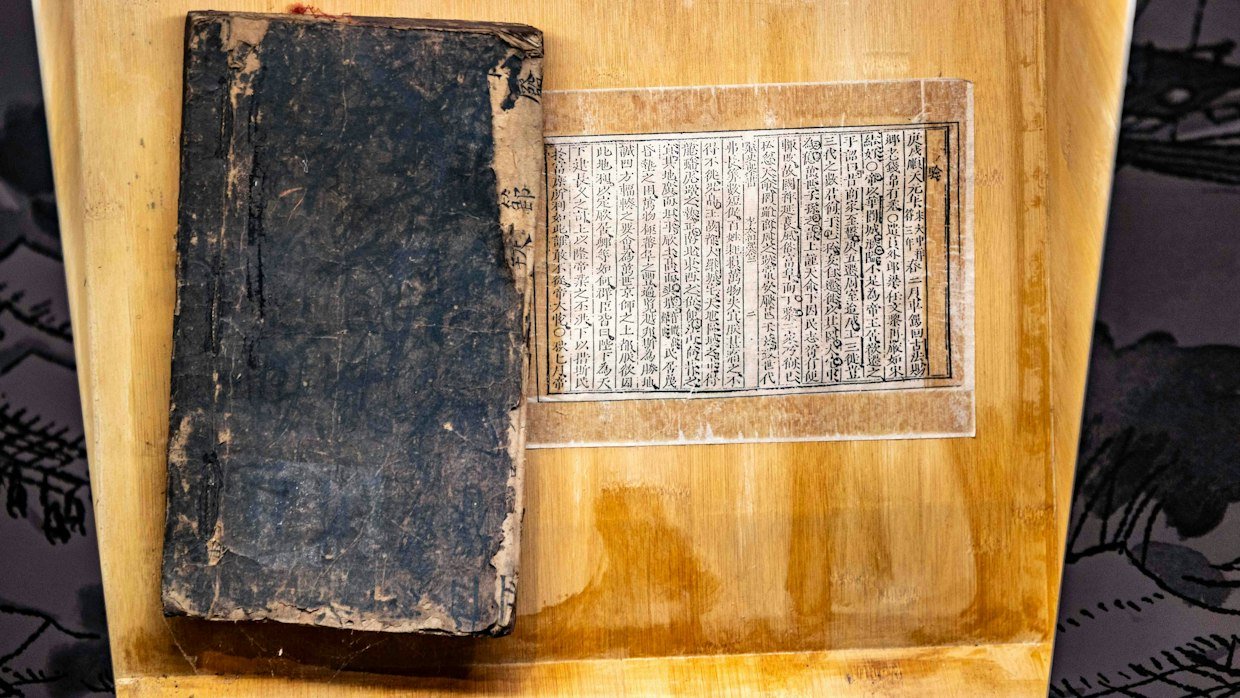 A large book next to a single small card.