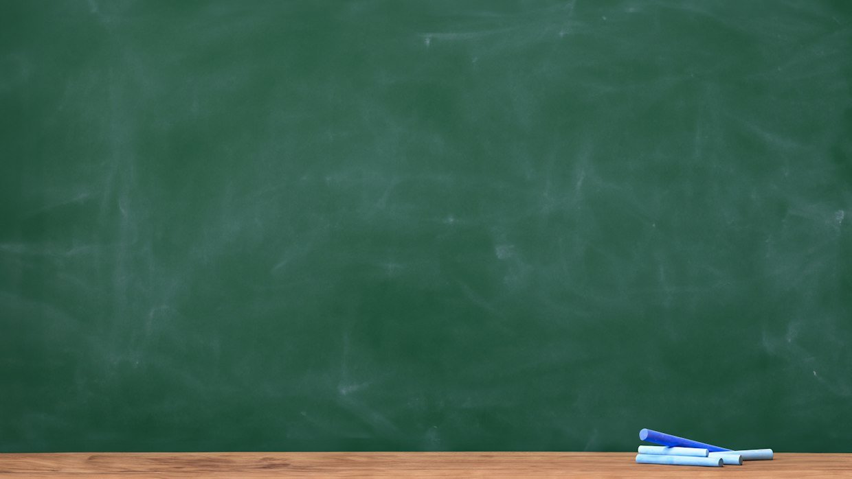 An empty chalkboard in a classroom.