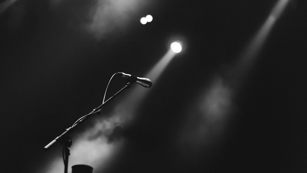 An empty stage with one microphone stand.