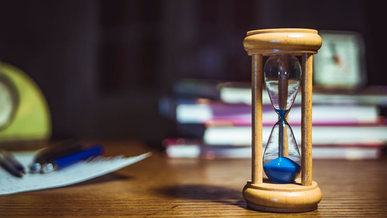 An hourglass standing on wood.