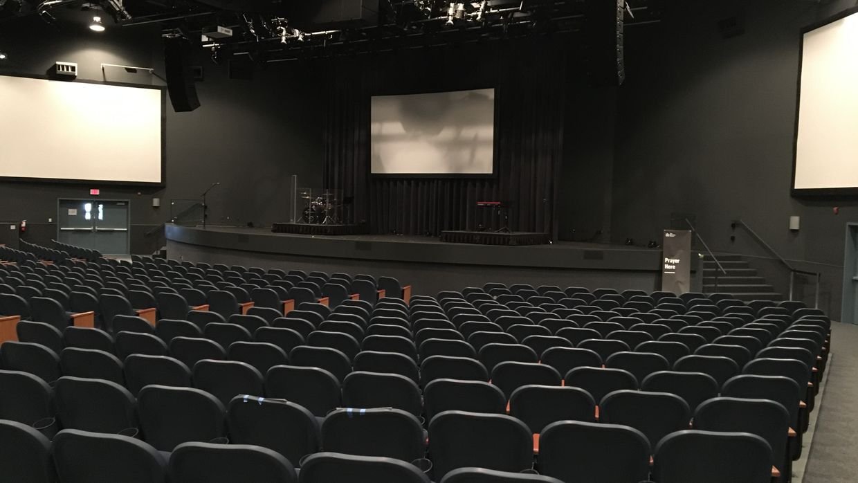 An audience seated facing a stage.