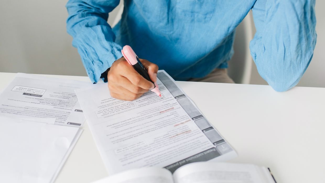 Someone marking a line in a printed document.