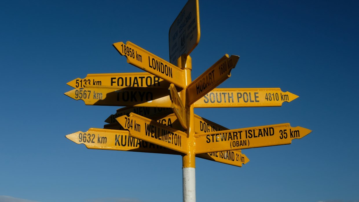 A signpost showing directions in several languages.
