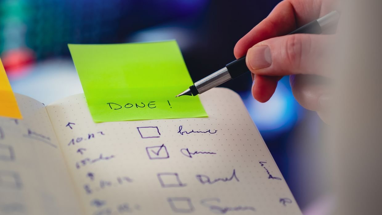A hand ticking items off a printed checklist.