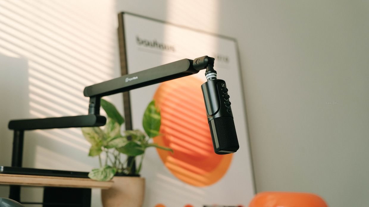 A hand adjusting a microphone arm.
