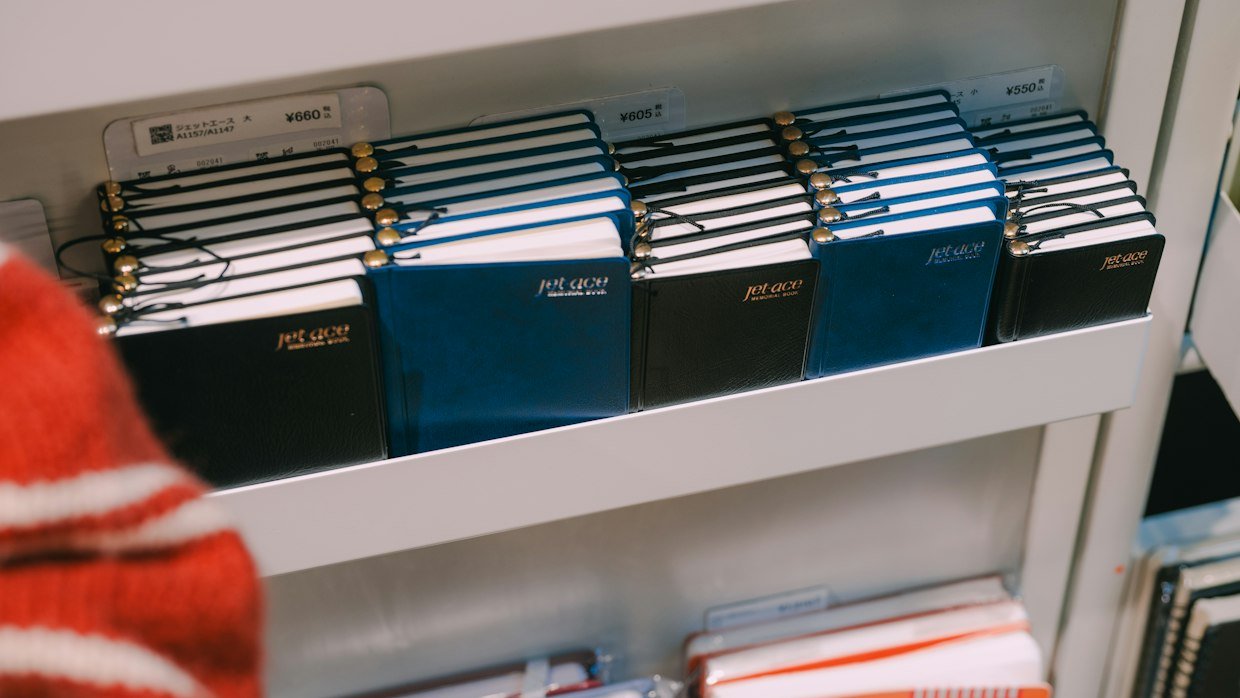A shelf holding rows of labelled notebooks.